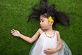 Asian Chinese little girl lying on the grass with flower Royalty Free Stock Photo