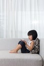 Asian Chinese little girl lying on the sofa with phone Royalty Free Stock Photo