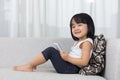 Asian Chinese little girl lying on the sofa with phone Royalty Free Stock Photo