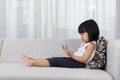 Asian Chinese little girl lying on the sofa with phone Royalty Free Stock Photo