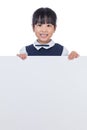 Asian Chinese little girl peeping behind white board Royalty Free Stock Photo