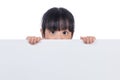 Asian Chinese little girl peeping behind white board Royalty Free Stock Photo