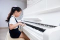 Asian Chinese little girl playing classical piano at home