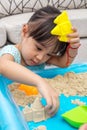 Asian Chinese little girl playing kinetic sand at home Royalty Free Stock Photo