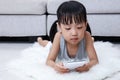 Asian Chinese little girl playing phone on the floor Royalty Free Stock Photo