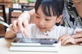 Asian Chinese little girl playing tablet computer with her mother Royalty Free Stock Photo