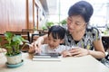 Asian Chinese little girl playing tablet computer with her mother Royalty Free Stock Photo