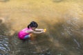 Asian Chinese little girl playing toy boat in the creek