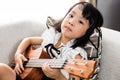 Asian Chinese little girl playing ukele Royalty Free Stock Photo