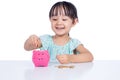 Asian Chinese little girl putting coins into piggy bank Royalty Free Stock Photo