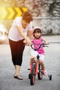 Asian Chinese little girl riding bicycle with mom guide Royalty Free Stock Photo