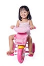 Asian chinese little girl riding a toy tricycle