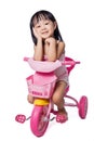 Asian chinese little girl riding a toy tricycle