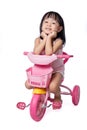 Asian chinese little girl riding a toy tricycle
