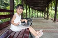 Asian Chinese little girl sitting on the bench with laptop Royalty Free Stock Photo