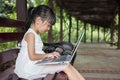 Asian Chinese little girl sitting on the bench with laptop Royalty Free Stock Photo
