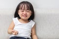 Asian Chinese little girl sitting on the sofa crying Royalty Free Stock Photo