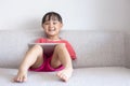 Asian Chinese little girl sitting on the sofa playing digital ta Royalty Free Stock Photo