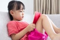 Asian Chinese little girl sitting on the sofa reading book Royalty Free Stock Photo