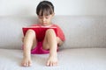 Asian Chinese little girl sitting on the sofa reading book Royalty Free Stock Photo