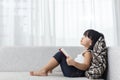 Asian Chinese little girl thinking while reading on the sofa