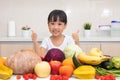 Asian Chinese little girl thumbs up with fruit and vegetable