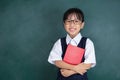 Asian Chinese little Girl in uniform standing against green blackboard