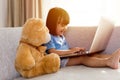 Asian Chinese little girl using laptop with teddy bear Royalty Free Stock Photo