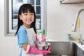 Asian Chinese little girl washing dishes in the kitchen Royalty Free Stock Photo