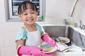 Asian Chinese little girl washing dishes in the kitchen Royalty Free Stock Photo