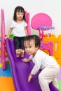 Asian Chinese little sister and brother playing on the slide Royalty Free Stock Photo