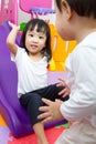 Asian Chinese little sister and brother playing on the slide Royalty Free Stock Photo