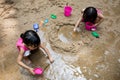 Asian Chinese little sister playing sand at creek