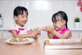 Asian Chinese little sisters making moon cake in the kitchen