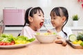 Asian Chinese little sisters making salad in the kitchen at home