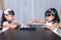 Asian Chinese little sisters playing chess together at home Royalty Free Stock Photo