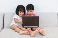 Asian Chinese little sisters playing computer