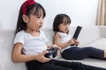 Asian Chinese little sisters playing TV games on the sofa Royalty Free Stock Photo