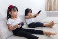 Asian Chinese little sisters playing TV games on the sofa Royalty Free Stock Photo