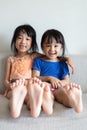 Asian Chinese little sisters sitting on the sofa