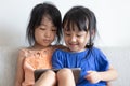 Asian Chinese little sisters using tablet on the sofa