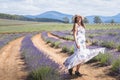 Portrait of beautiful romantic woman floral dress stylish hat dancing in field of lavender flowers Royalty Free Stock Photo