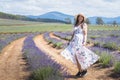 Portrait of beautiful romantic woman floral dress and stylish hat in field of lavender flowers Royalty Free Stock Photo