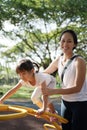 Asian Chinese Mother helping daughter climb up obstacle course