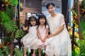 Asian Chinese mother and daughters sitting on a swing