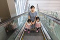 Asian Chinese mother and daughters taking escalator at MRT Station Royalty Free Stock Photo