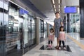 Asian Chinese mother and daughters waiting for transit at station