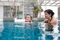 Asian Chinese mother and daugther playing at swimming pool Royalty Free Stock Photo