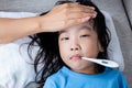 Asian Chinese mother measuring little girl forehead for fever