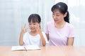 Asian Chinese mother teaching daughter mathematics by counting f Royalty Free Stock Photo